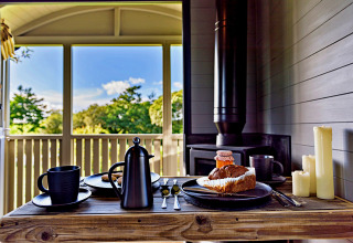 Petit déjeuner dans la 'Elen' Gypsy Hut : café, gâteau, bougies et vue sur la nature, Royaume-Uni.