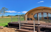 Modern houten huisje 'Deep Dale' in het Verenigd Koninkrijk met glazen balustrade en zicht op grasveld.