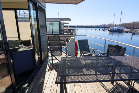 Terrace of houseboat 'Family & Friends LP 3 / 3 Personen' in Germany with view over the water and marina.