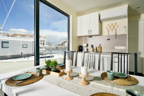 Spiseområde på husbåd Family & Friends LP 3 med udsigt over havnen og moderne indretning i Tyskland.