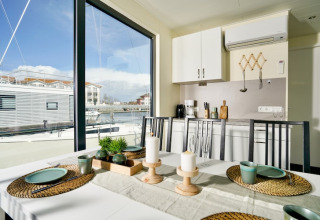 Spiseområde på husbåd Family & Friends LP 3 med udsigt over havnen og moderne indretning i Tyskland.