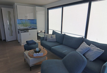 Modernes Wohnzimmer und Küchenzeile auf dem Hausboot Family & Friends LP 4 mit großer blauer Couch.