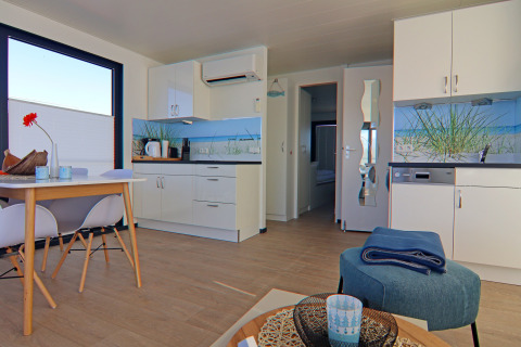 Cocina y comedor modernos en plano abierto de una casa flotante, decorada con estilo costero en Alemania.
