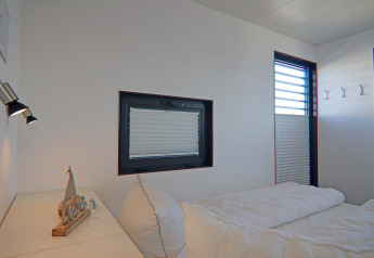 Bedroom inside Houseboat Family & Friends LP 4 in Germany featuring modern windows, bed and white decor.