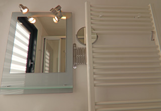 Bathroom with mirror, lights, towel radiator and window on Houseboat Family & Friends in Germany.