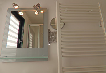 Salle de bain avec miroir, lumières, porte-serviettes et fenêtre sur la péniche Family & Friends en Allemagne.