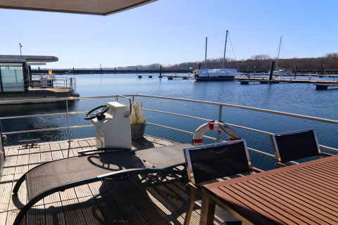 Sonnige Terrasse des Hausboots Family & Friends LP 4 mit Blick auf Jachthafen und Wasser in Deutschland.
