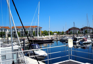 View from houseboat 'Family & Friends LP 4' overlooking marina with sailboats and apartments in Germany.
