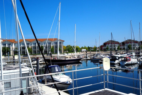 View from houseboat Family & Friends LP 4 over marina with sailboats and modern apartments in Germany.
