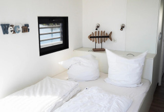 Dormitorio moderno y luminoso en una casa flotante en Alemania con cama doble y decoración de pez.