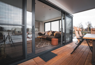 View of the cozy living room and deck seating area with a river backdrop on the Houseboat in Höxter.
