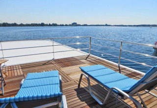 Solterrasse på husbåden Floating 44 med to liggestole og udsigt over søen ved solskin i Tyskland.
