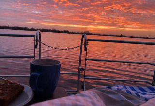 Solopgang over søen set fra en husbåd med morgenmad, kaffe og smuk himmel i Tyskland.