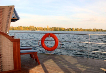 Uitzicht vanaf het dek van houseboat Floating 44 met reddingsboei en meer in Duitsland.
