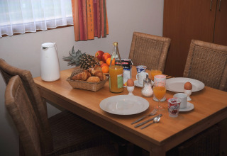 Ontbijttafel met fruit, broodjes, sap, eieren en koffie in Waldferienpark Gerolstein 2, Duitsland.