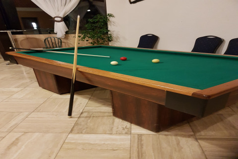 Biljarttafel met groen doek, drie ballen en twee keus in een chalet bij Waldferienpark Gerolstein, Duitsland.