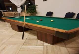Biljarttafel met groen doek, drie ballen en twee keus in een chalet bij Waldferienpark Gerolstein, Duitsland.