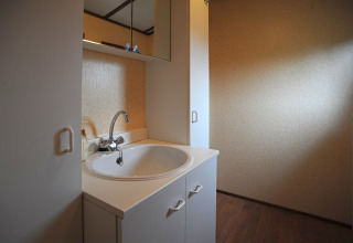 Moderne wastafel met witte kast en spiegel in de badkamer van chalet Waldferienpark Gerolstein 2, Duitsland.