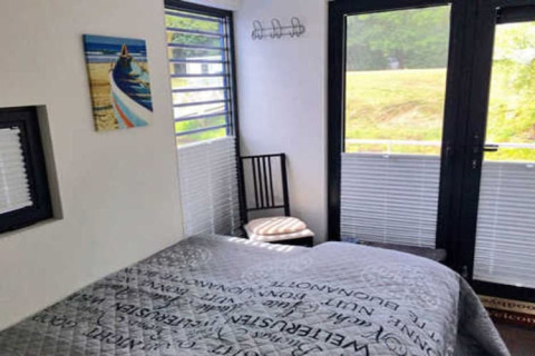 Schlafzimmer im Hausboot Floating 44 / Boot 7 in Deutschland mit Doppelbett, Fenstern und Ausblick.
