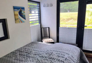 Schlafzimmer im Hausboot Floating 44 / Boot 7 in Deutschland mit Doppelbett, Fenstern und Ausblick.