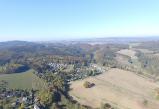Luchtfoto van Waldferienpark Gerolstein 2 chalet in Duitsland, omgeven door heuvels en open velden.