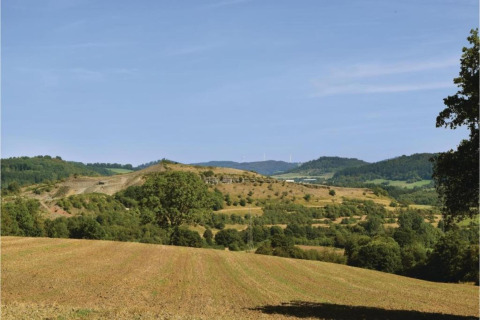 Zicht op glooiende heuvels en akkers bij Waldferienpark Gerolstein 2, Duitsland, onder een heldere hemel.