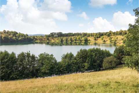 Uitzicht op een meer met groene heuvels en bomen bij Waldferienpark Gerolstein 2, Duitsland.