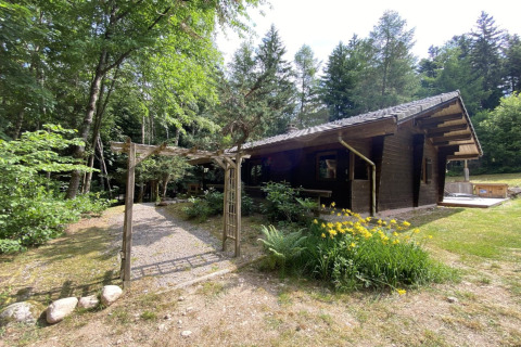 Buitenaanzicht van LE FISHING LODGE, houten chalet met Noors bad, gelegen tussen bossen in Frankrijk.