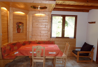 Gemütlicher Essbereich im Chalet „Ronds Chetys“ in Frankreich mit Holzverkleidung und rustikaler Dekoration.