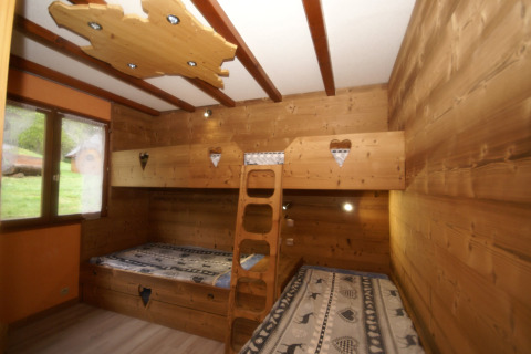 Camera in legno con letti a castello e cuori, finestra panoramica, in chalet Ronds Chetys, Francia.