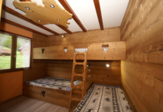 Camera in legno con letti a castello e cuori, finestra panoramica, in chalet Ronds Chetys, Francia.