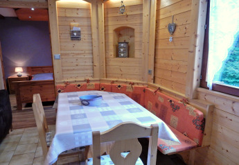 Gemütliche Essecke mit Holzmöbeln und Eckbank im Chalet «Ronds Chetys» in Frankreich.