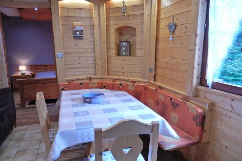 Zona pranzo in legno con panca ad angolo nel chalet «Ronds Chetys» in Francia.
