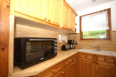 Cucina dello chalet Ronds Chetys in Francia con forno tostapane, macchina da caffè e mobili in legno.