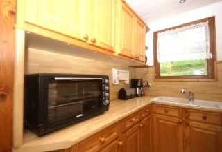 Cucina dello chalet Ronds Chetys in Francia con forno tostapane, macchina da caffè e mobili in legno.