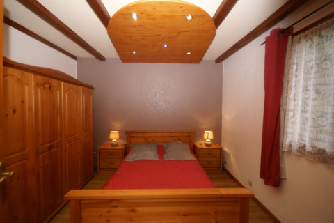 Camera da letto nello chalet 'Ronds Chetys' in Francia con mobili in legno e lampade da comodino.