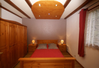 Camera da letto nello chalet 'Ronds Chetys' in Francia con mobili in legno e lampade da comodino.
