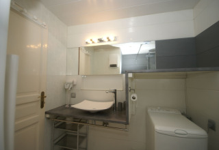 Bagno moderno nello chalet Ronds Chetys in Francia con lavabo, specchio, lavatrice e asciugacapelli.