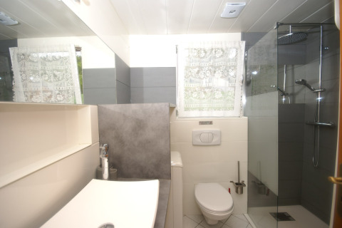 Bagno moderno presso lo chalet Ronds Chetys in Francia, con doccia, wc e lavabo illuminati da luce naturale.