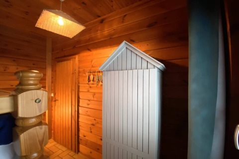 Binnenzicht op het houten chalet LE FISHING LODGE in Frankrijk met houten muren en een kast.