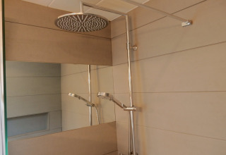 Doccia moderna con grande soffione rotondo e specchio al chalet 'Ronds Chetys' in Francia.