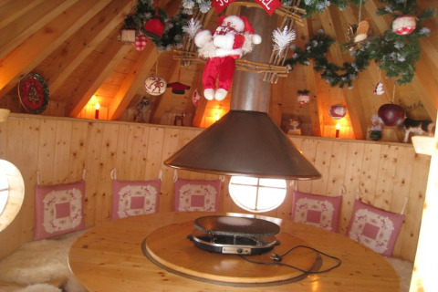 Interno accogliente dello chalet 'Ronds Chetys' in Francia, decorato con cuscini e addobbi natalizi.