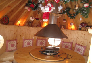 Interno accogliente dello chalet 'Ronds Chetys' in Francia, decorato con cuscini e addobbi natalizi.
