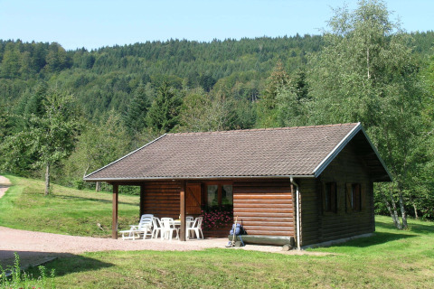 Chalet 'Ronds Chetys' in Francia, immerso nella natura tra alberi e prati verdi su uno sfondo collinare.