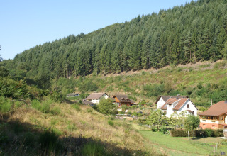 Vista degli chalet «Ronds Chetys» in Francia, immersi tra colline verdi e paesaggi boschivi.