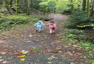 Due bambini vestiti colorati corrono mano nella mano su un sentiero vicino al chalet 'Ronds Chetys' in Francia.