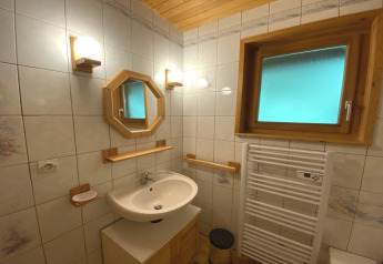 Badkamer met houten omlijst spiegel, verwarmd handdoekrek en raam in chalet in Frankrijk.