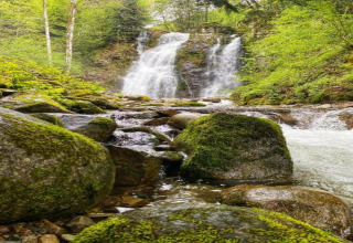 Foto di una cascata tra rocce ricoperte di muschio vicino allo chalet 'Ronds Chetys' in Francia.