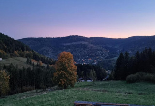 Vista dal chalet Ronds Chetys in Francia su colline verdi, una valle tranquilla e case sparse al tramonto.