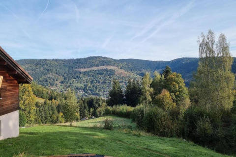 Vista dal chalet 'Ronds Chetys' in Francia con colline verdi, boschi e montagne sullo sfondo.